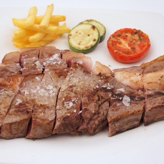 Beef chuletón steak with a vegetable garnish